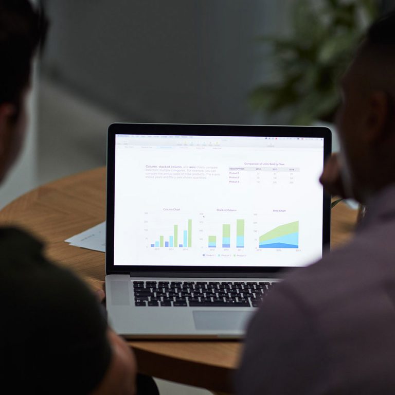 Two people on laptop looking at stats