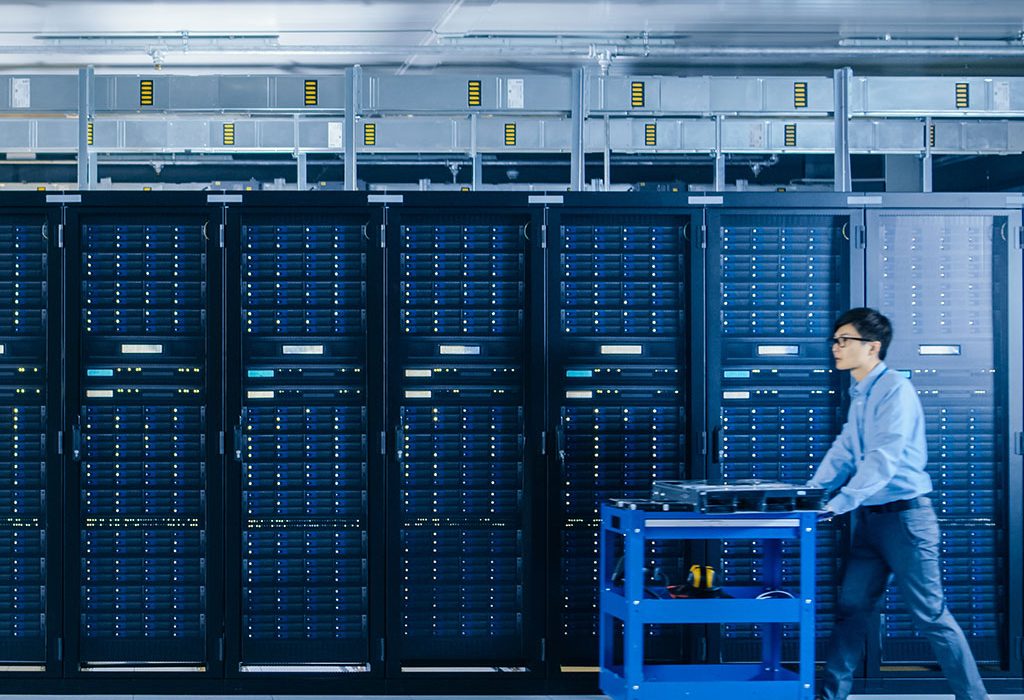 Man pushing cart through server room
